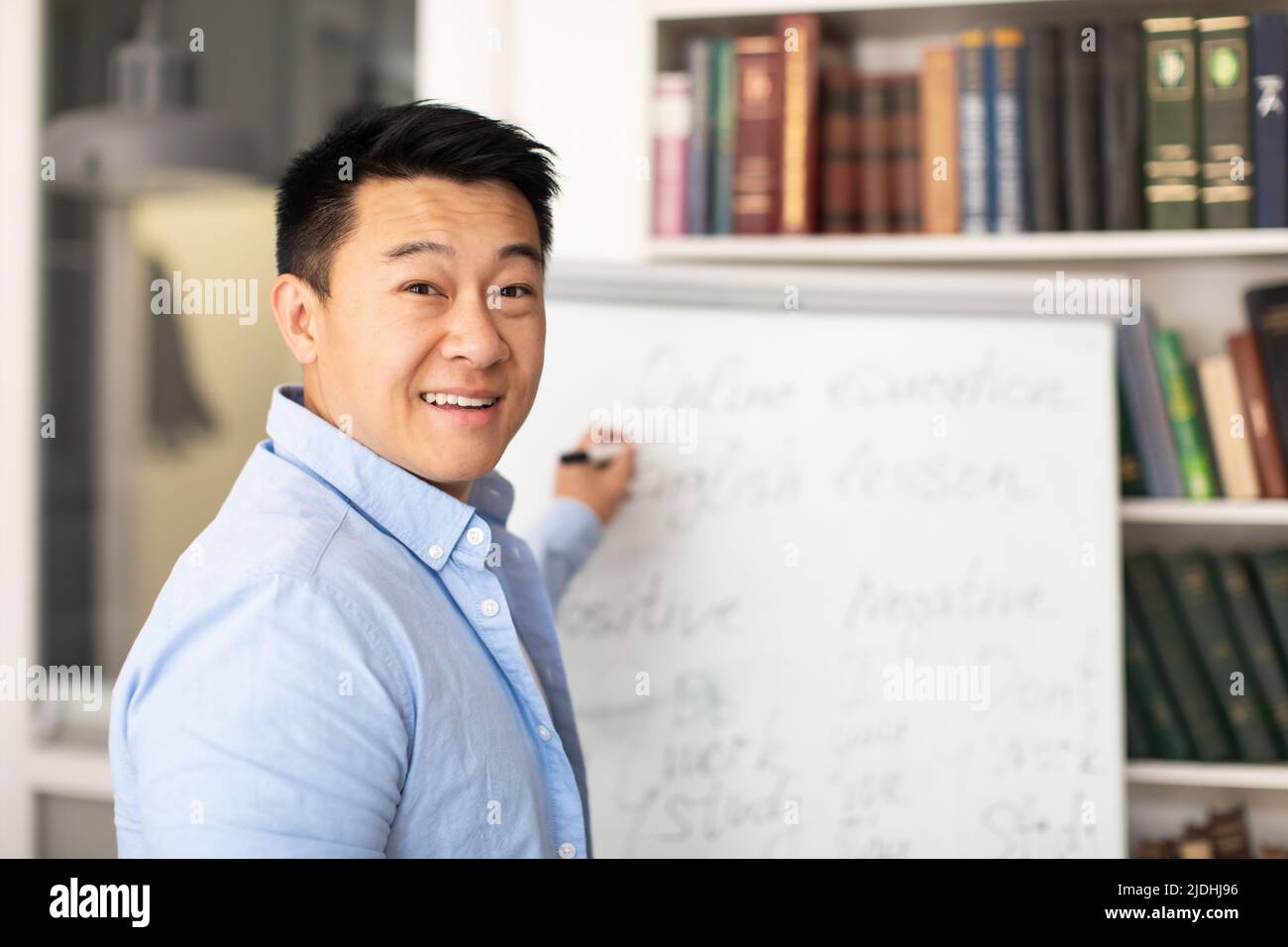 Koreanischer Tutor Mann Schreibt Auf Whiteboard Englisch Unterrichten Im Klassenzimmer Stockfoto