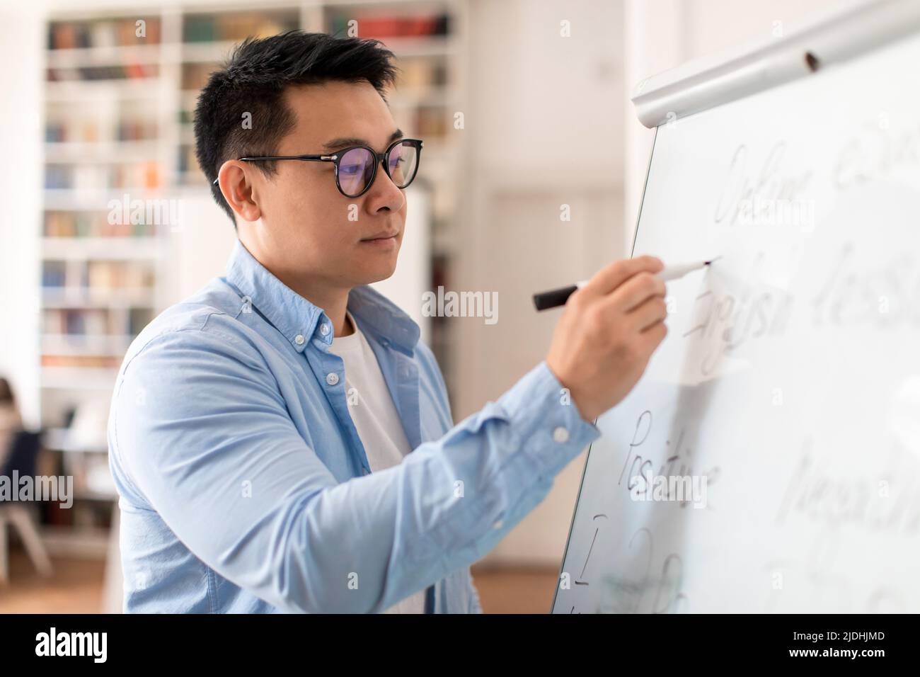 Koreanischer Lehrer Mann Schreibt Grammatikregeln Auf Whiteboard Im Klassenzimmer Stockfoto