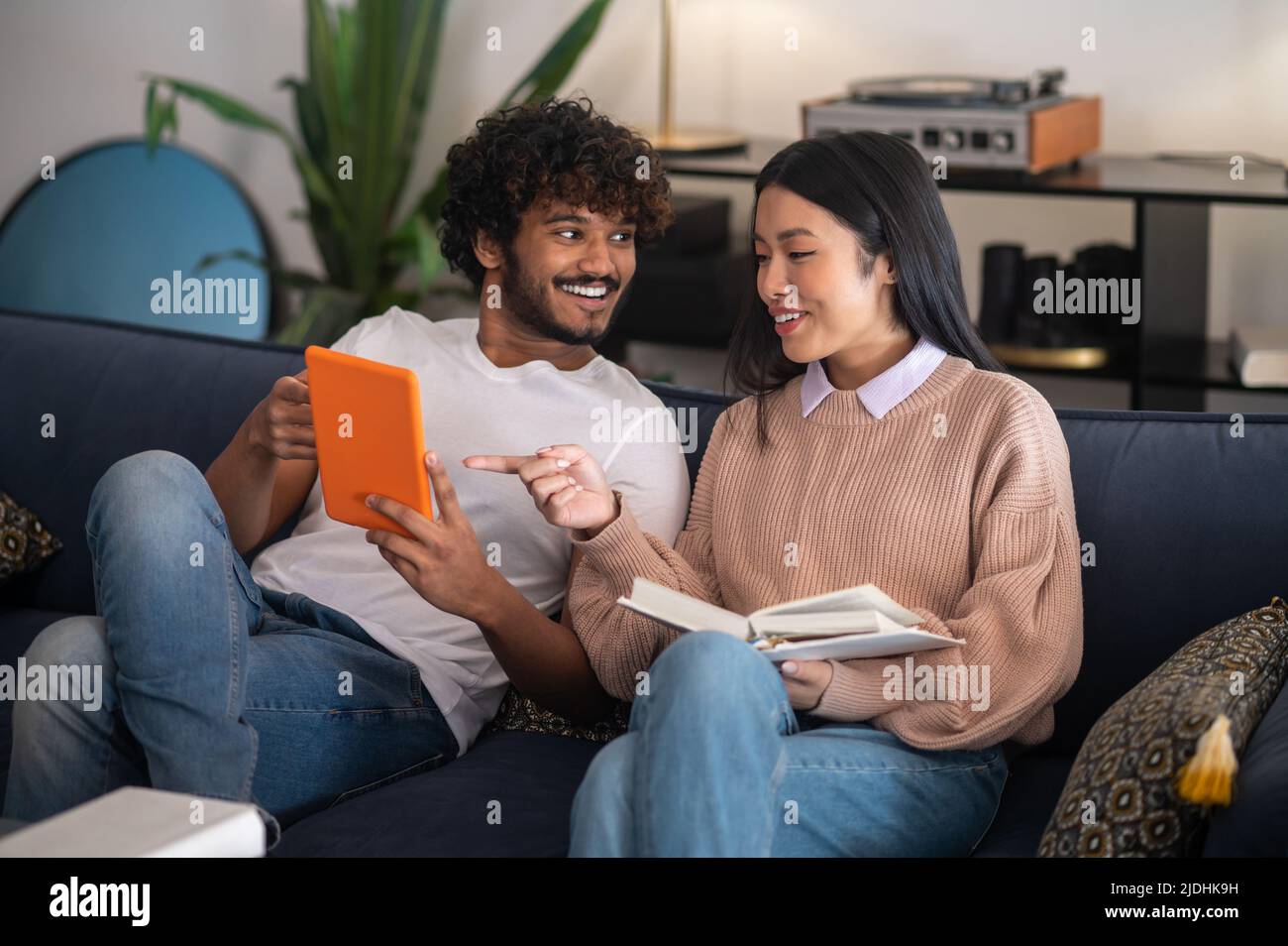 Junger Mann und junge Frau sitzen auf dem Sofa und reden Stockfoto