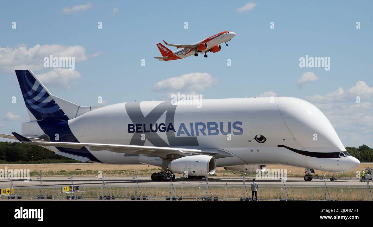 21. Juni 2022, Brandenburg, Schönefeld: Ein Transportflugzeug des Typs Airbus Beluga XL ist auf der Internationalen Luft- und Raumfahrtausstellung ILA gelandet, während im Hintergrund ein easyJet-Flugzeug abhebt. Die Airshow am Flughafen Schönefeld ist ab 22,06 Uhr geöffnet. - 26.06.2022. Foto: Wolfgang Kumm/dpa Stockfoto