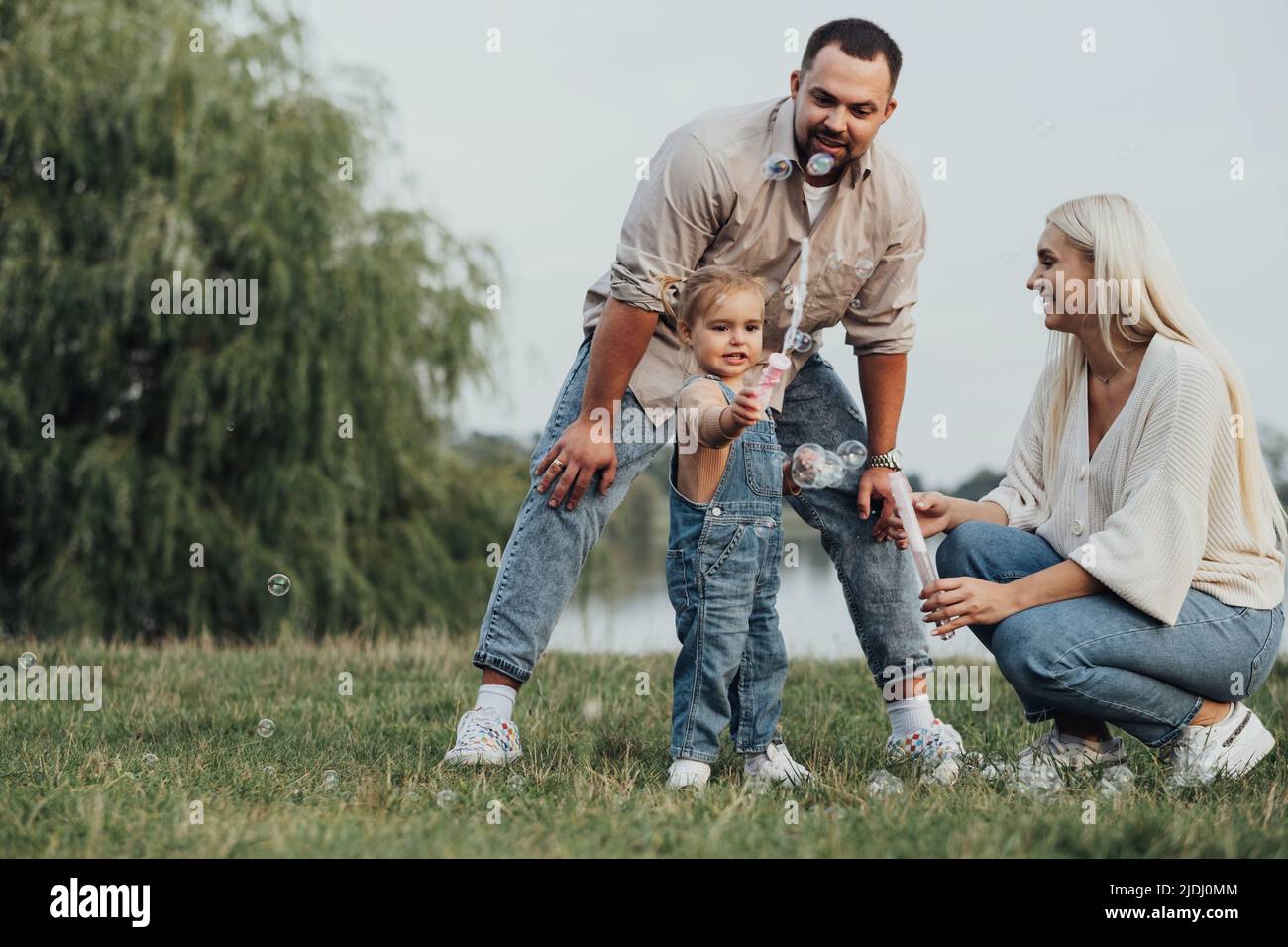 Porträt einer glücklichen jungen Familie, einer Mutter und eines Vaters mit ihrer kleinen Tochter, die sich außerhalb der Stadt Vergnügen Stockfoto