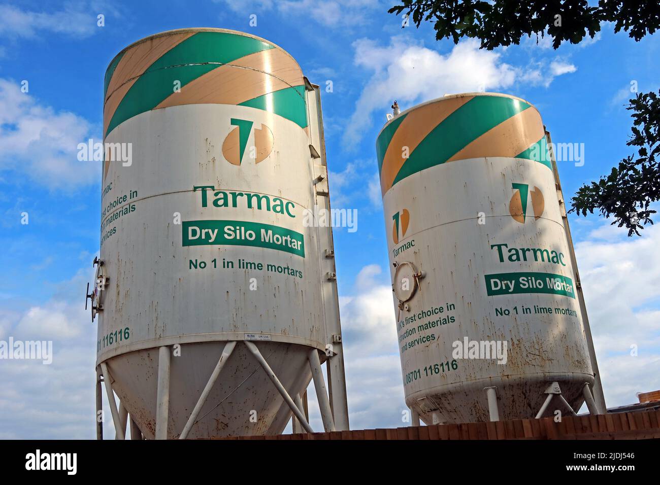 Zwei funktionierende Tarmac Dry Silo Mörteltrichter auf einer Baustelle in Warrington, Cheshire, England, Großbritannien Stockfoto