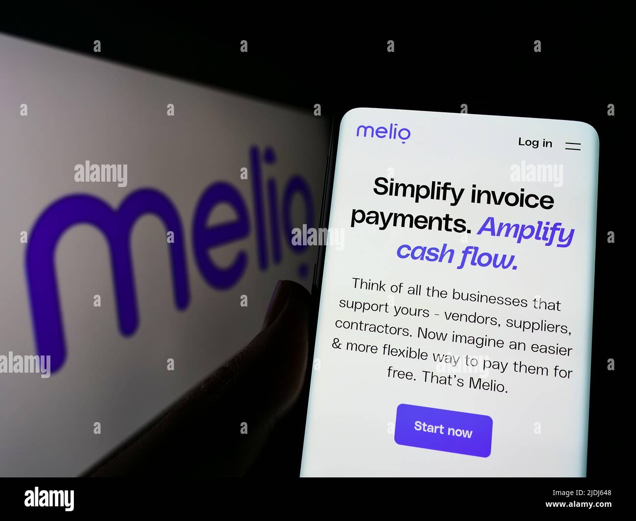 Person, die Mobiltelefon mit der Webseite des US-Finanzunternehmens Melio Payments Inc. Auf dem Bildschirm vor dem Logo hält. Konzentrieren Sie sich auf die Mitte des Telefondisplays. Stockfoto