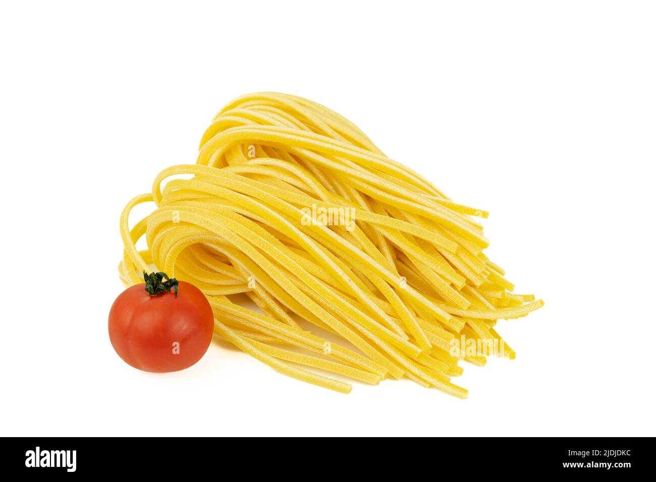 Ein paar Spaghetti und ganze Tomaten zum Kochen auf weißem Hintergrund. Stockfoto