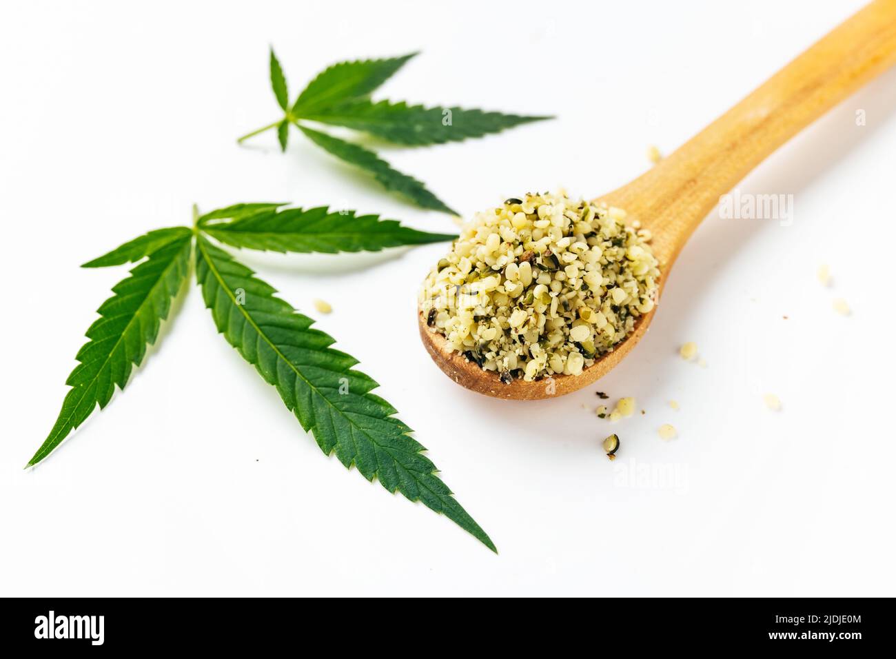 Grüne Cannabisblätter und Löffel mit abgeschälten Samen isoliert auf weißem Hintergrund. Ernährungsrechtliche Verwendung von Marihuana. Omega-3-Fette. Superfood Stockfoto