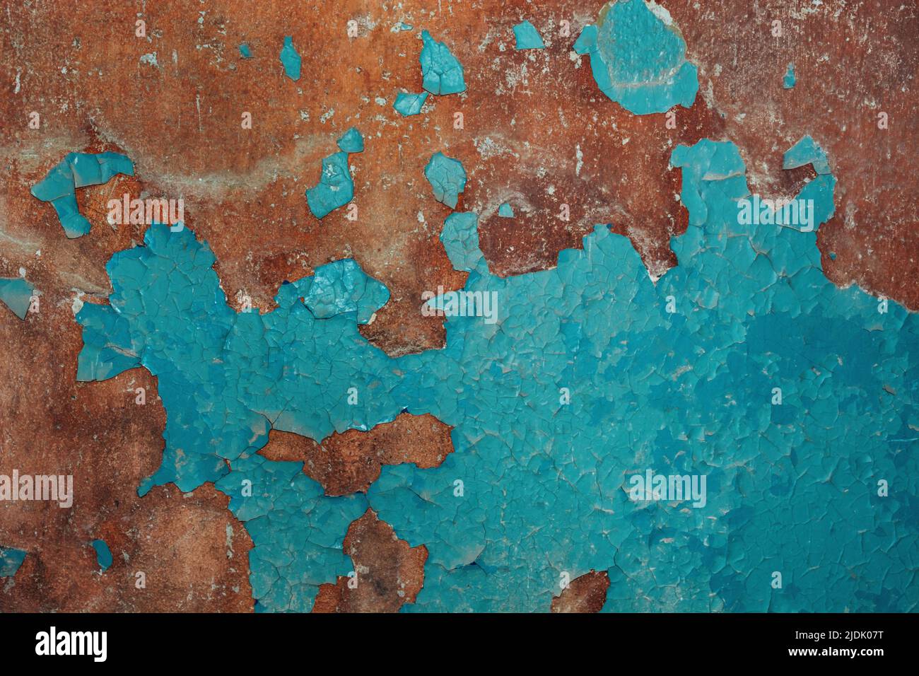 Braun-blaue Farbe von abblätternder, rissiger Farbe an der alten Wand. Für Textur oder Hintergrund, Muster. Weicher selektiver Fokus Stockfoto