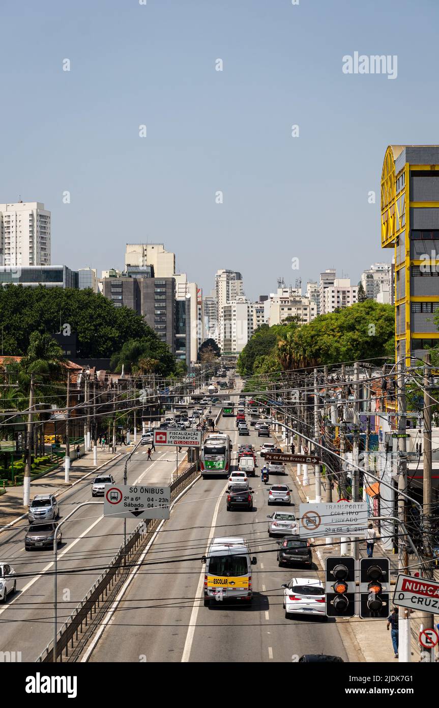 Francisco Matarazzo Avenue mit vielen vorbeifahrenden Autos und Luftkabeln im Agua Branca Bezirk mit Wolkenkratzern auf der Rückseite. Stockfoto