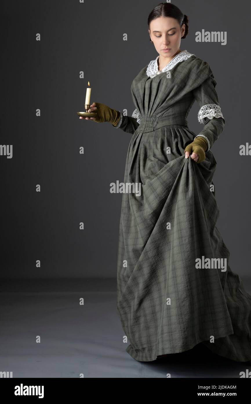 Eine viktorianische Dienstmädchen oder eine Arbeiterin mit dunkelgrünem Karomuster und Rock Stockfoto