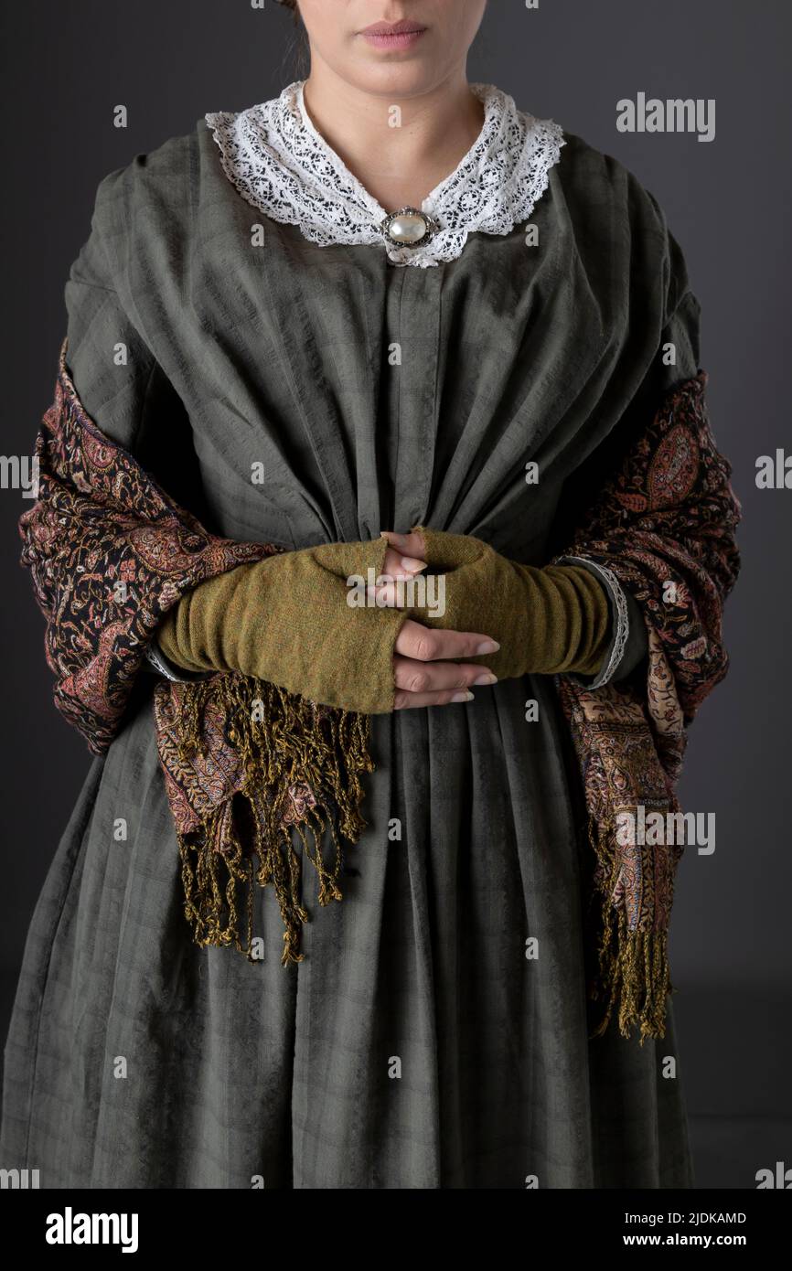 Eine viktorianische Dienstmädchen oder eine Arbeiterin mit dunkelgrünem Karomuster und Rock Stockfoto
