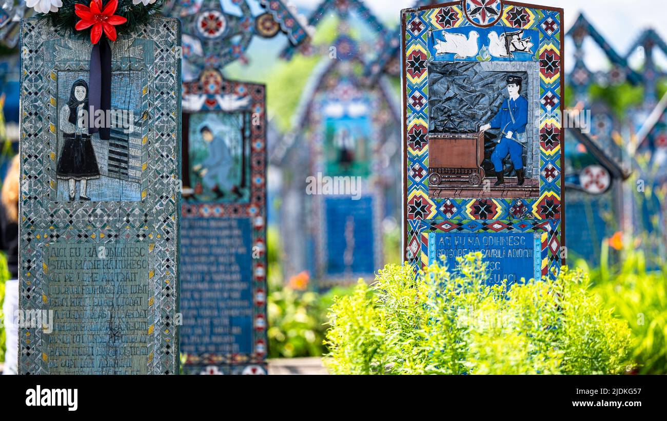 Sapanta, Maramures, Rumänien - 17. Juni 2022: Bemalte blaue Holzdenkmäler in einem einzigartigen in der Welt 'Merry Cemetery'. Stockfoto