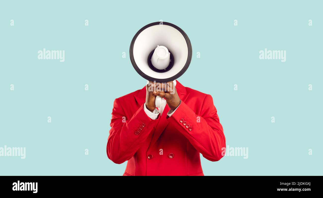 Der Mann, der sein Gesicht hinter einem Lautsprecher versteckt, macht laute Werbung auf einem pastellfarbenen hellblauen Hintergrund. Stockfoto