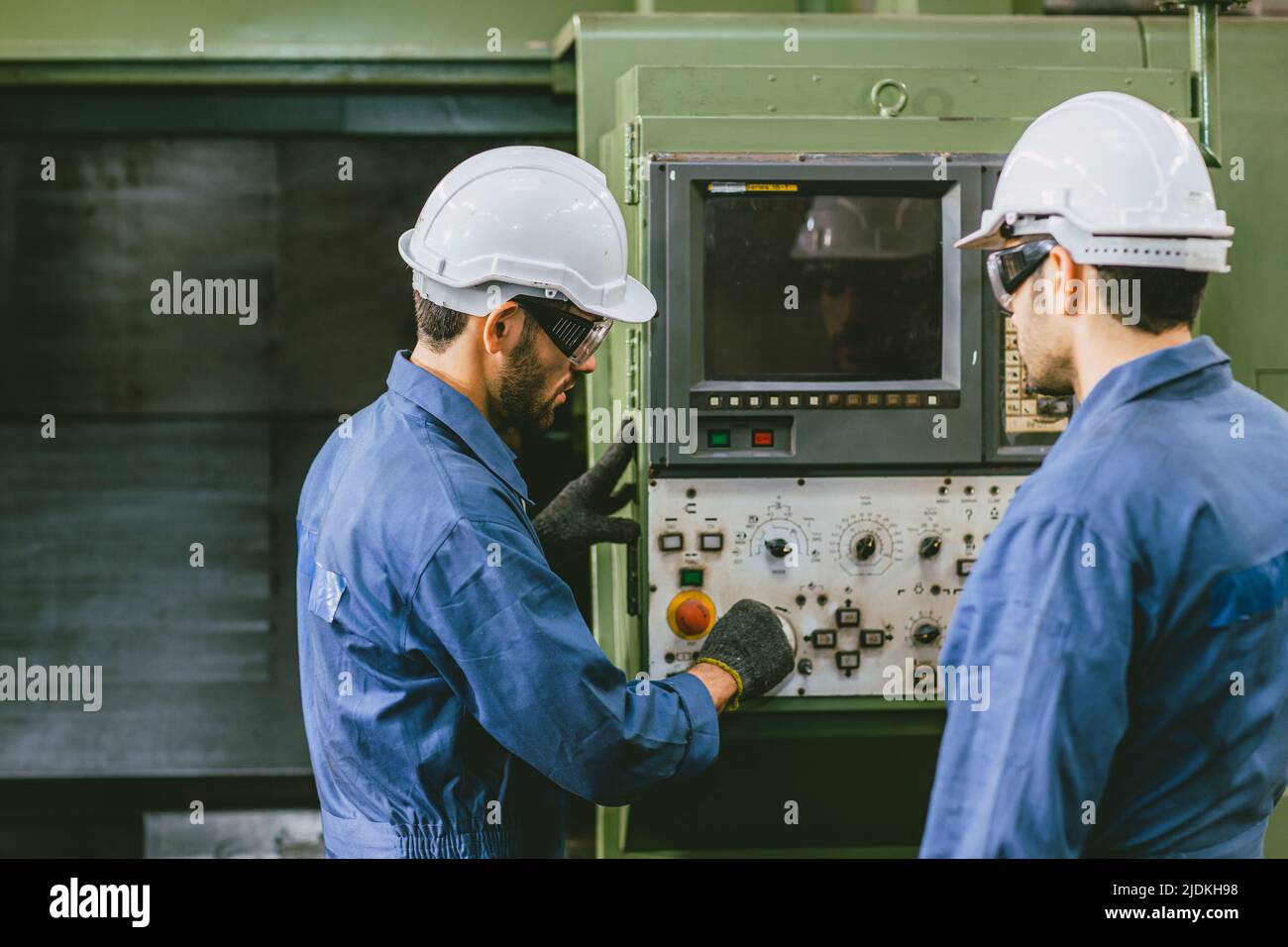 Erfahrene Techniker Mitarbeiter arbeiten zusammen in Metallfabrik bedienen Setup CNC-Maschine. Stockfoto