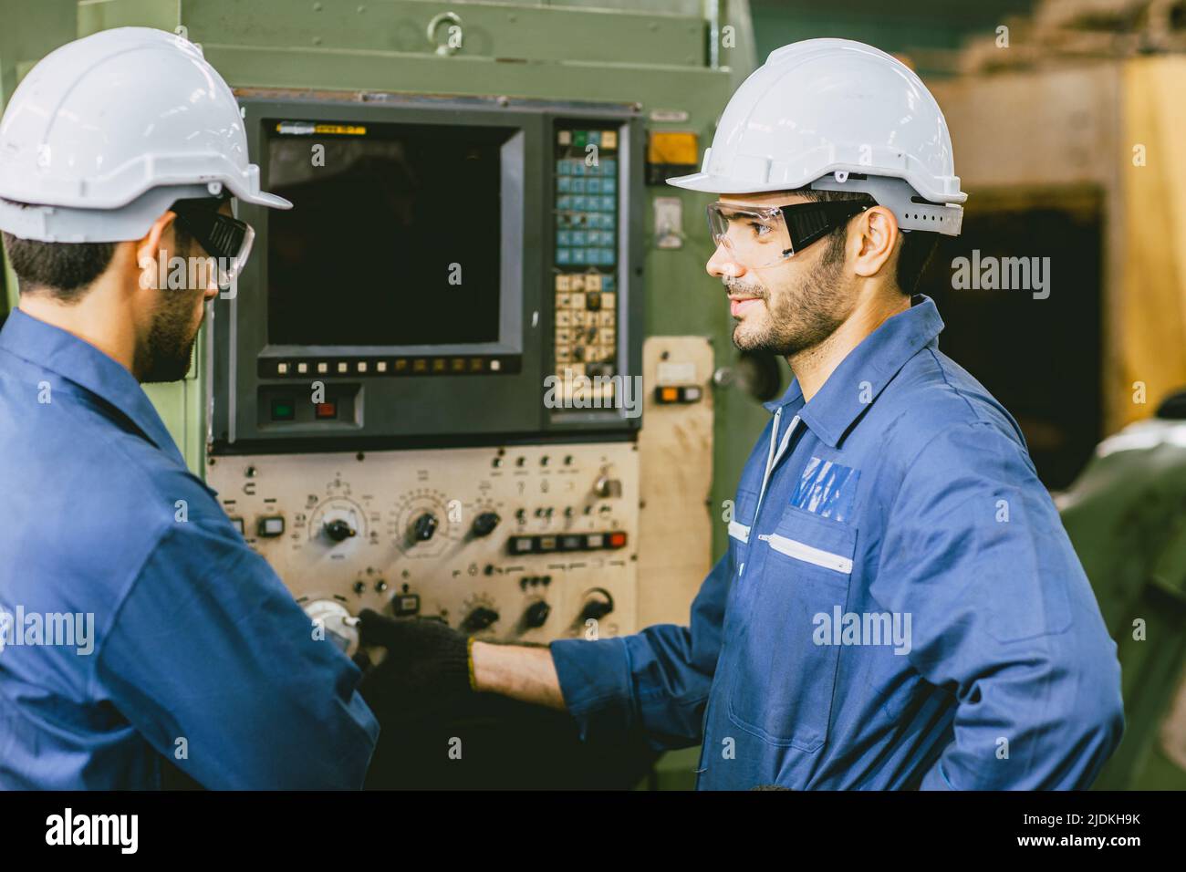 Erfahrene Techniker Mitarbeiter arbeiten zusammen in Metallfabrik bedienen Setup CNC-Maschine. Stockfoto