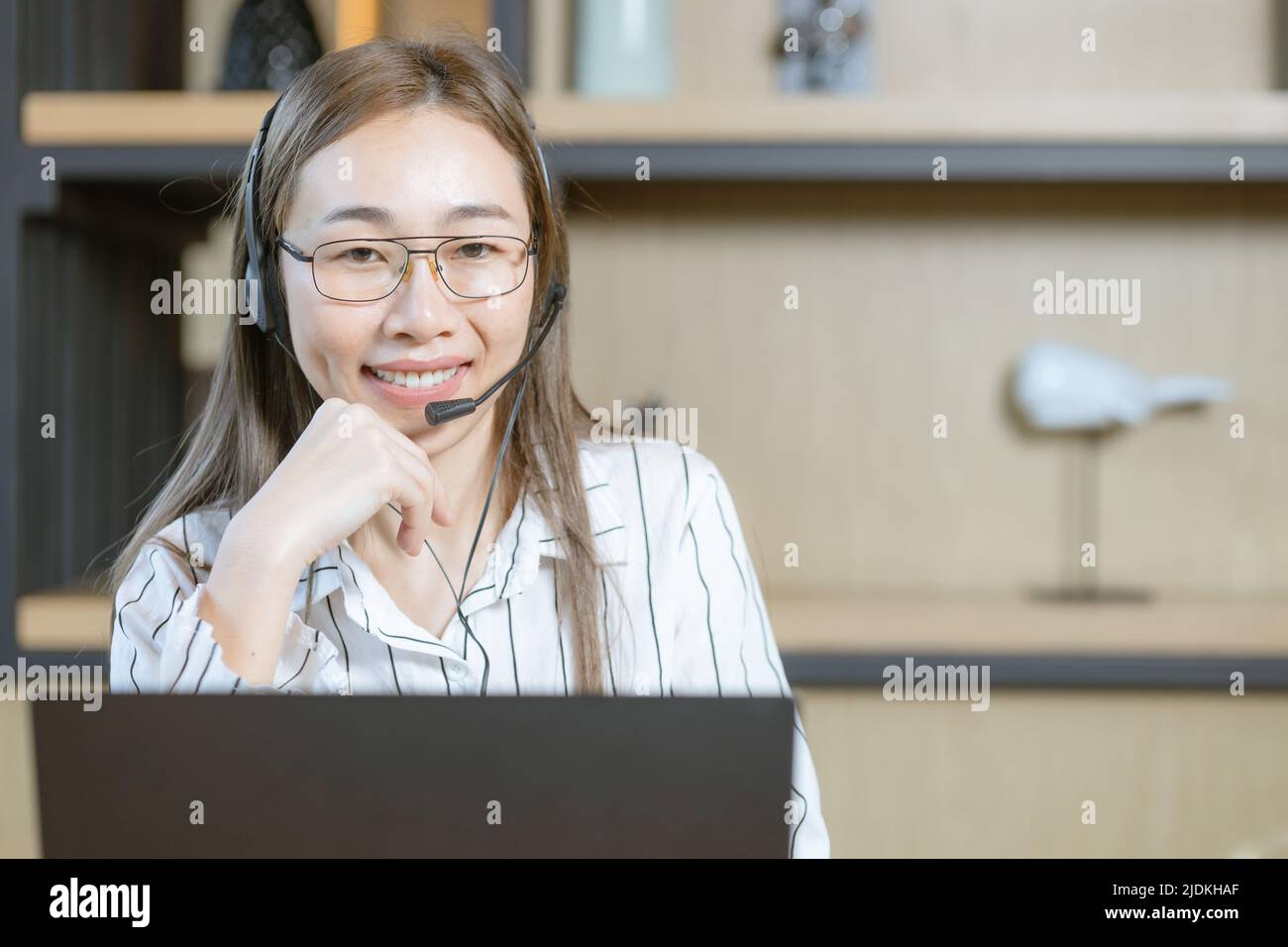 Geschäftlich arbeitende Frau arbeitet im Kundensupport-Team des Callcenters. Die Mitarbeiter stehen mit einem glücklichen Lächeln auf dem Headset zur Verfügung Stockfoto