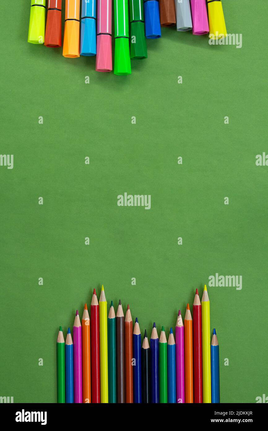 Farbige Filzstifte und Bleistifte in einer Reihe unten und oben oder an der Seite mit leerem Platz für Text auf Grün. Zurück zur Schule Konzept, Zeichnung. SPA kopieren Stockfoto