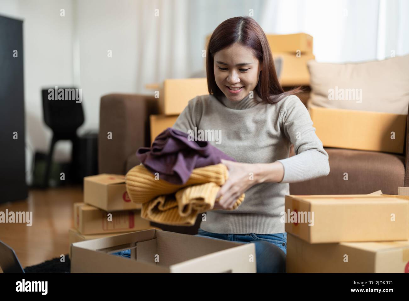 Asiatische weibliche Online-Shop Kleinunternehmer Verpackung Paket Post Versand Box Vorbereitung Lieferung Paket auf dem Tisch. E-Commerce Stockfoto