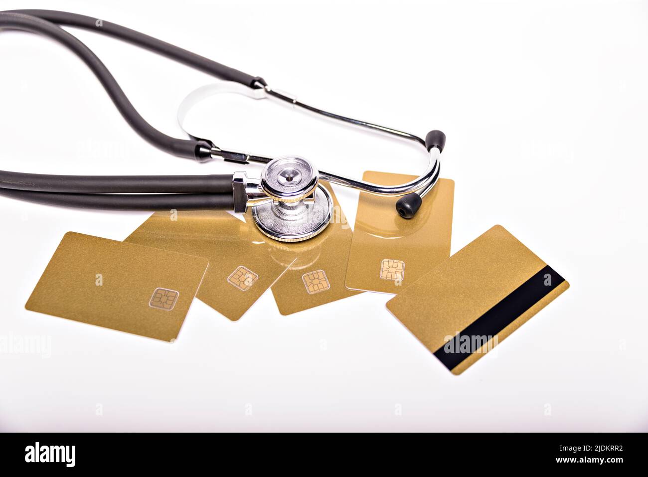 Gesundheitskosten konzeptionelles Bild: Stethoskop und Geldhaufen auf einer medizinischen Karte, Symbol der Gesundheitskosten oder Krankenversicherung, isoliert auf Stockfoto