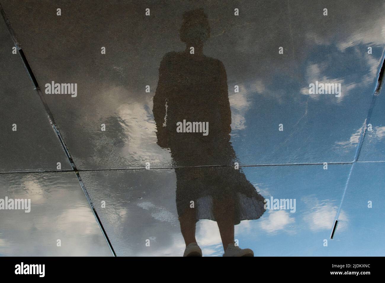 Spiegelung der Silhouette einer Frau auf einem Wasserspiegel. Rätselhaft und geisterhaft. Für Text platzieren. Stockfoto