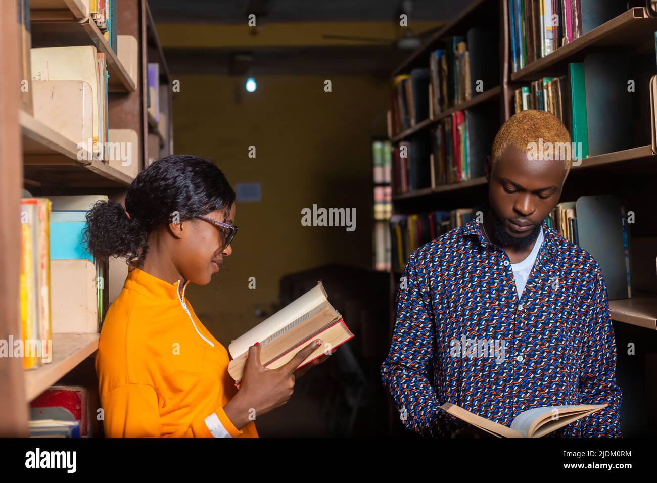 High School - zwei Schüler mit Buch in der Bibliothek studieren für die Prüfung Stockfoto