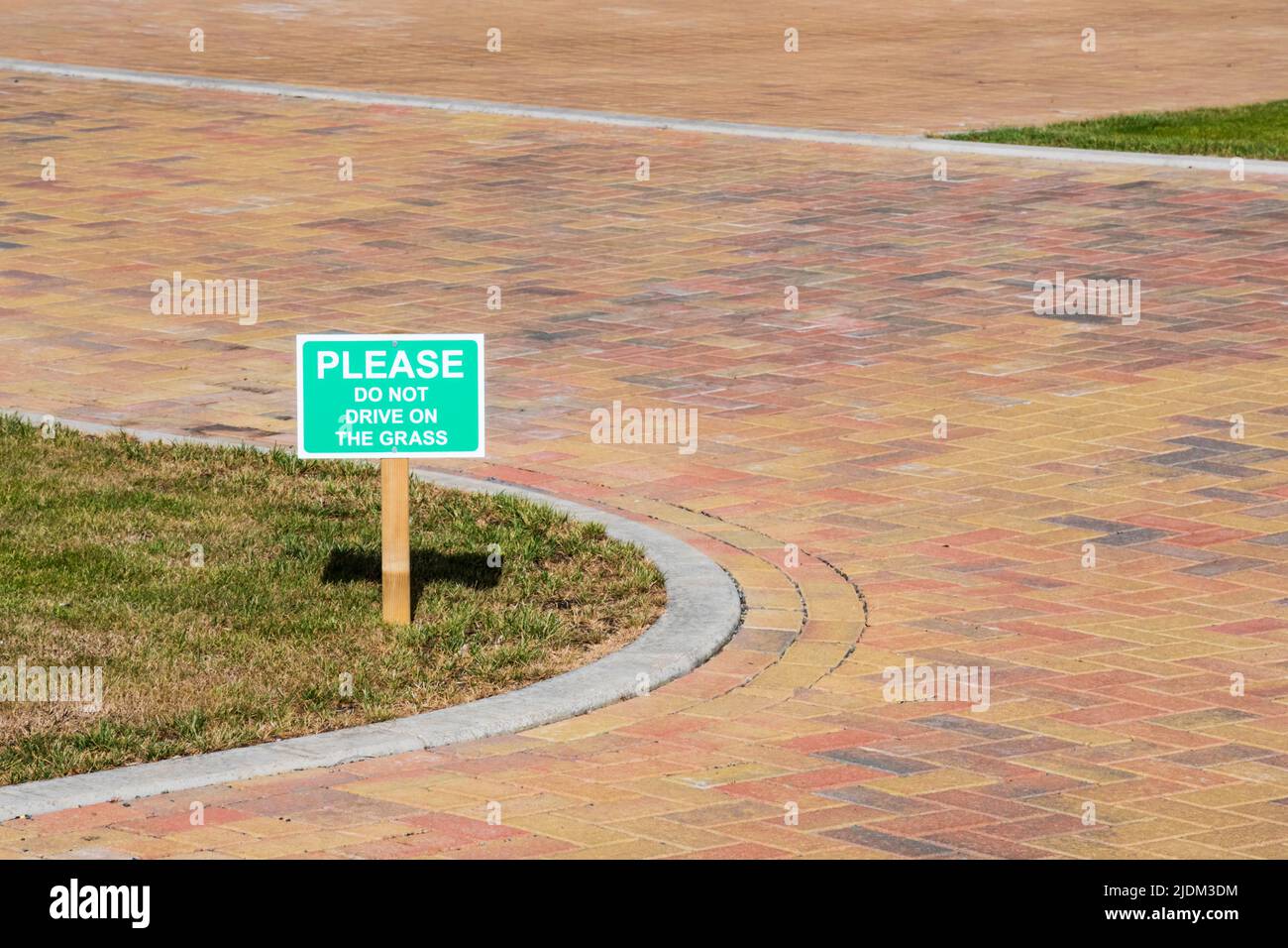 Ein Schild mit der Aufschrift Bitte fahren Sie nicht auf dem Gras. Stockfoto