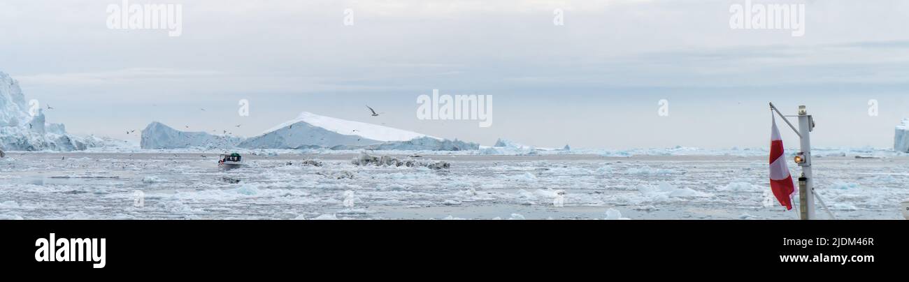 Panorama schöne Eisberge mit Fischerboot in Geenland von einer Bootsfahrt von Ilulissat Stockfoto