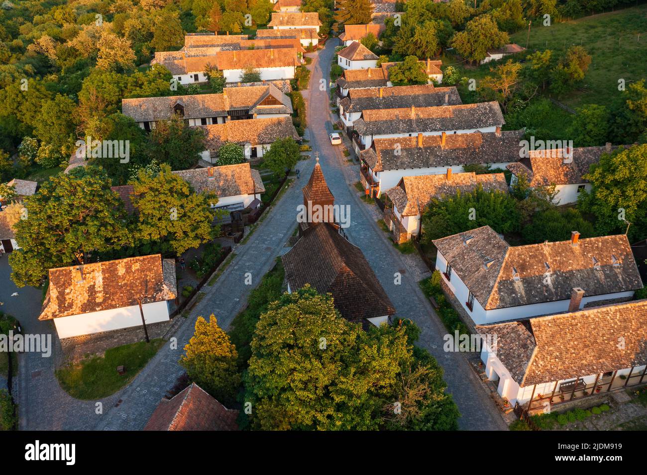 Luftaufnahme über ein kleines Dorf namens Hollókő. Berühmtes Touristenziel, UNESCO-Weltkulturerbe Stockfoto
