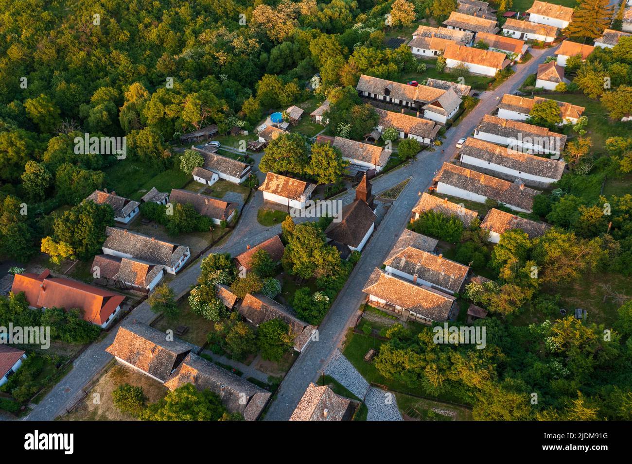 Luftaufnahme über ein kleines Dorf namens Hollókő. Berühmtes Touristenziel, UNESCO-Weltkulturerbe Stockfoto