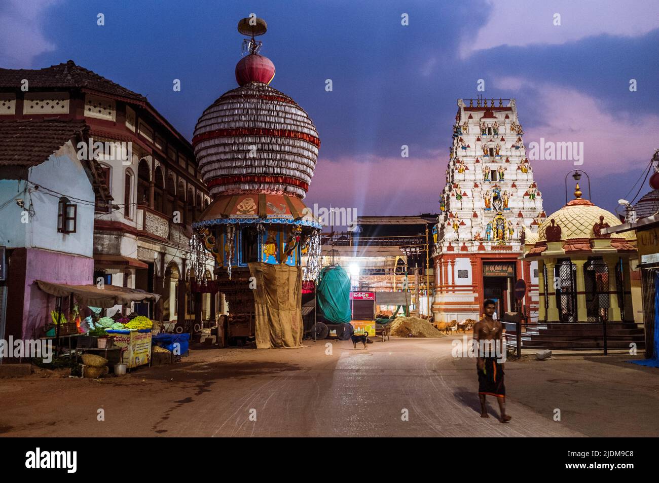 Udupi, Karnataka, Indien : EIN Pilger geht vor Sonnenaufgang vom Krishna-Tempel aus dem 13. Jahrhundert und von großen Prozessionswagen draußen. Der Tempel wurde gefunden Stockfoto