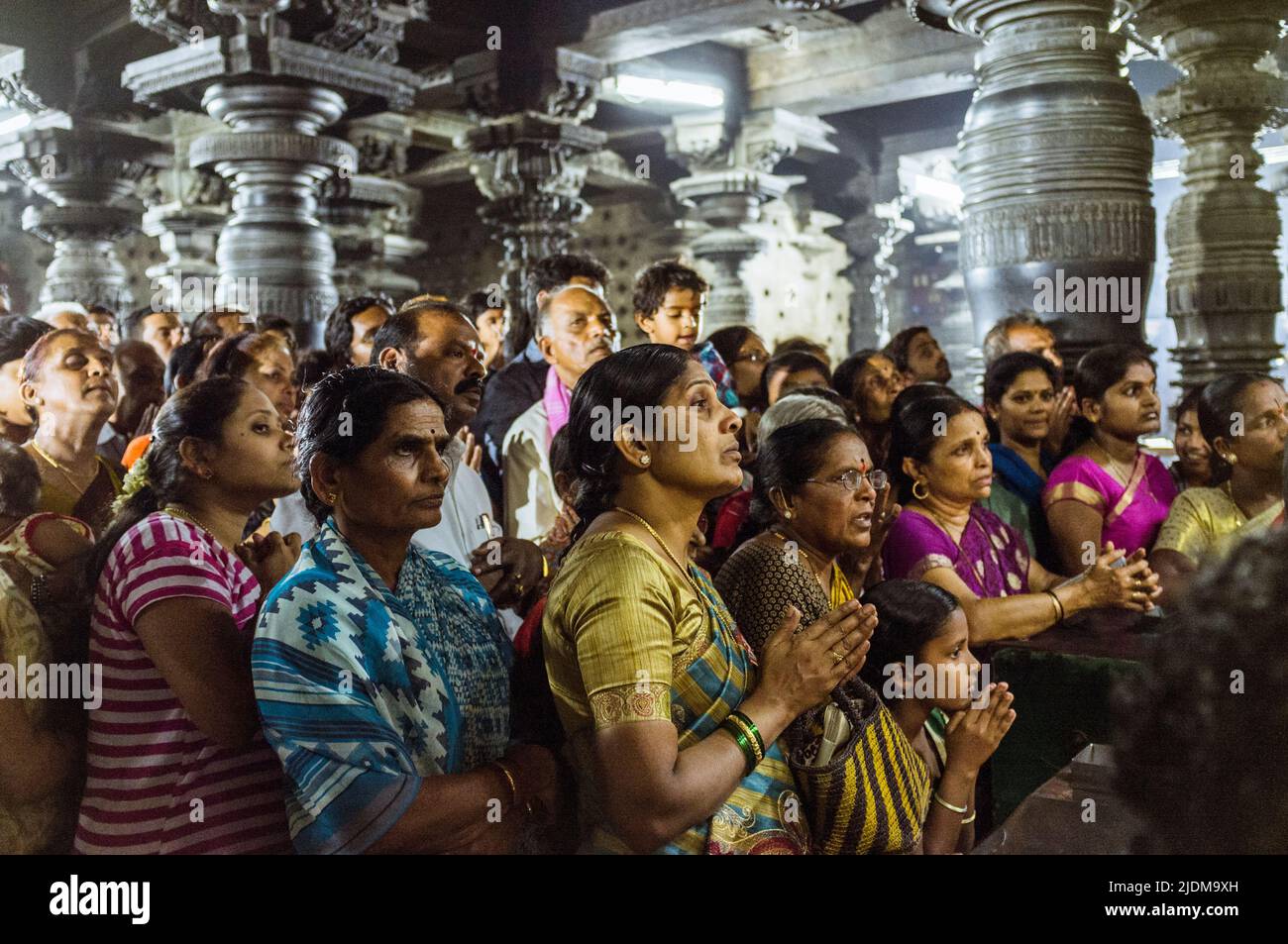 Belur, Karnataka, Indien : Eine Gruppe von Anhängern steht auf Gebet innerhalb des Channakeshava Tempels aus dem 12th. Jahrhundert vor der rituellen Puja-Zeremonie. Stockfoto