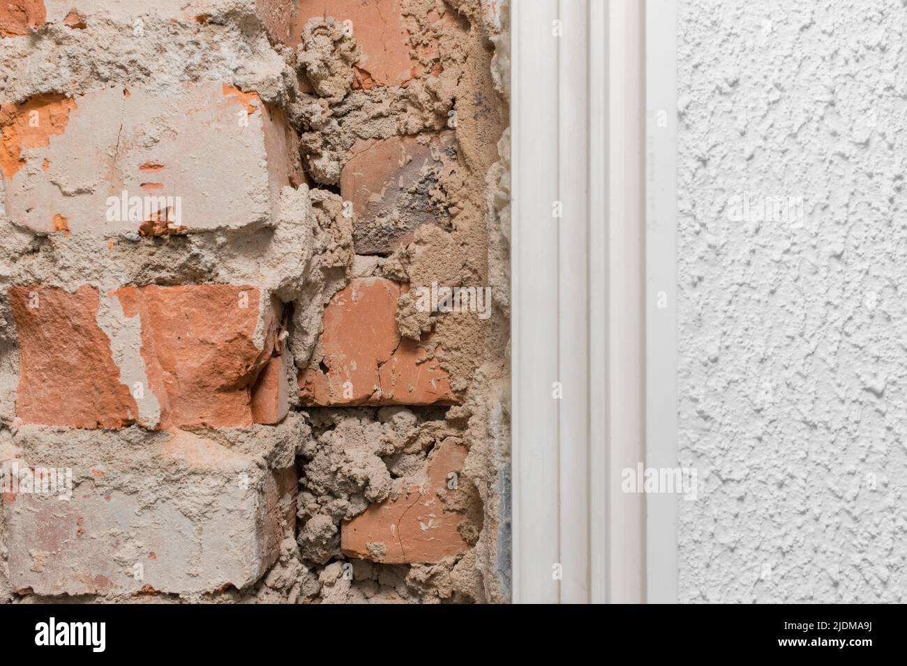 Altes Ziegelfragment der unvollendeten Baureparatur und Rekonstruktion der Mauer aus der Nähe. Stockfoto