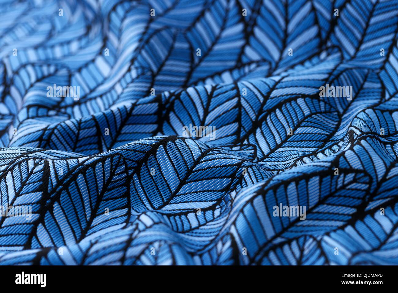 Blau zerknittert Stoff mit Blätter drucken strukturierten Hintergrund Stockfoto
