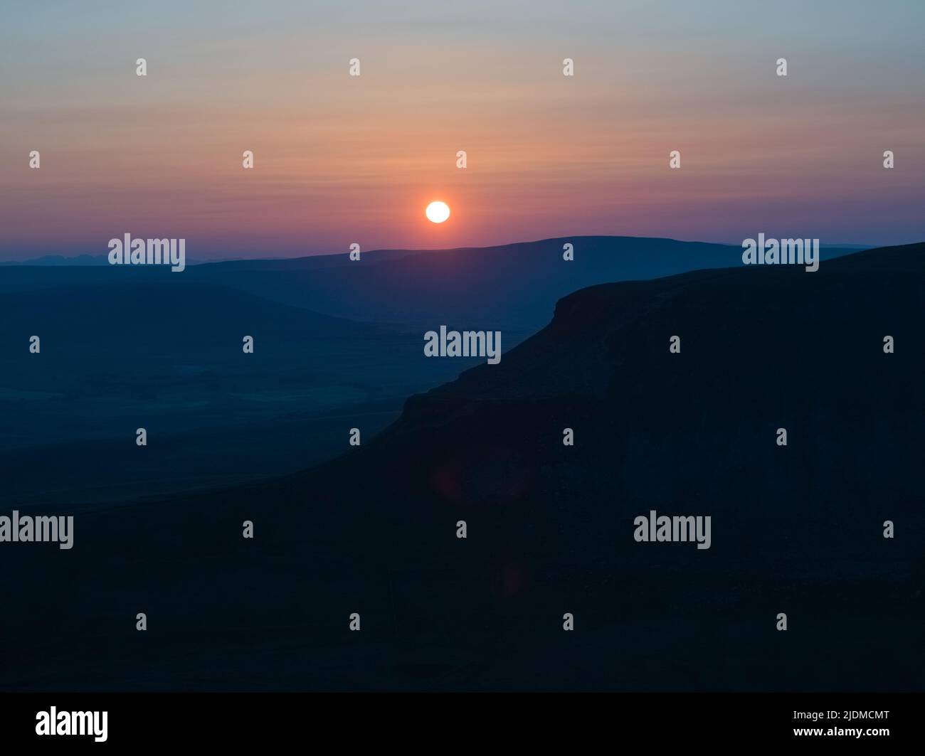 Sonnenuntergänge der unverwechselbaren Silhouette von Penyghent einer von drei Hügeln, die die Yorkshire 3 Peaks bilden Stockfoto