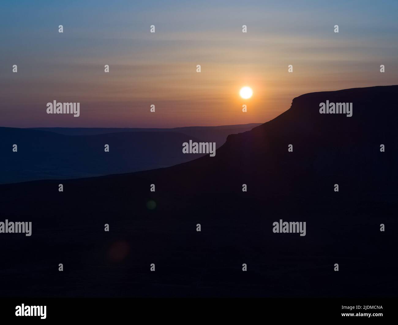 Sonnenuntergänge der unverwechselbaren Silhouette von Penyghent einer von drei Hügeln, die die Yorkshire 3 Peaks bilden Stockfoto