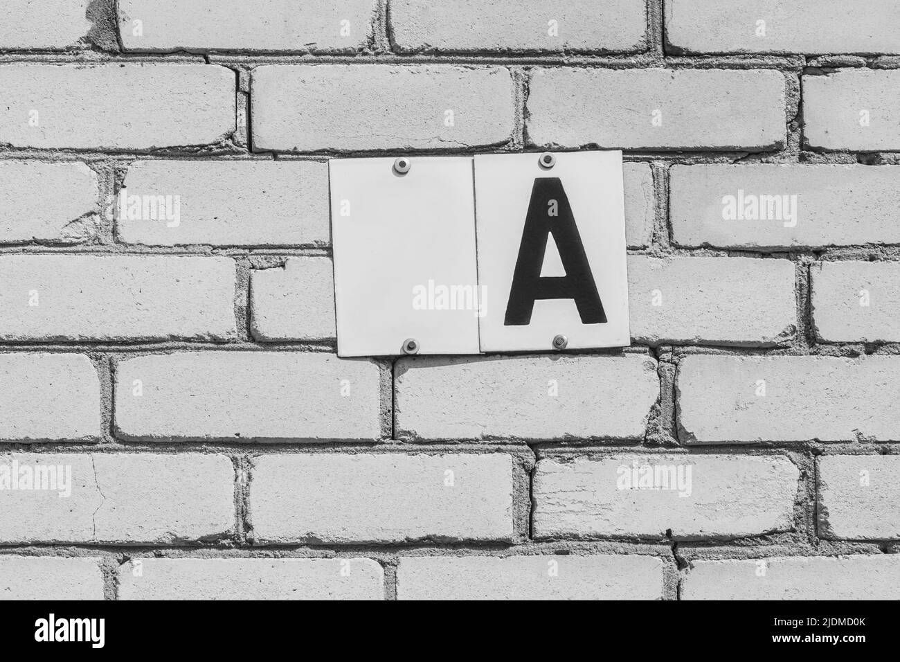 Schreiben Sie ein Zeichen Ein Zeichen weiß leer Objekt für Text und Design-Vorlage Hausnummer Fragment leer abstrakt Hause Ziegelwand Symbol. Stockfoto