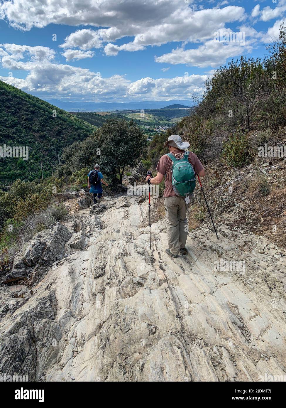 Spanien, Molinaseca, Castilla y Leon. Wanderer, die den Camino nach Molinaseca hinaufsteigen. Stockfoto