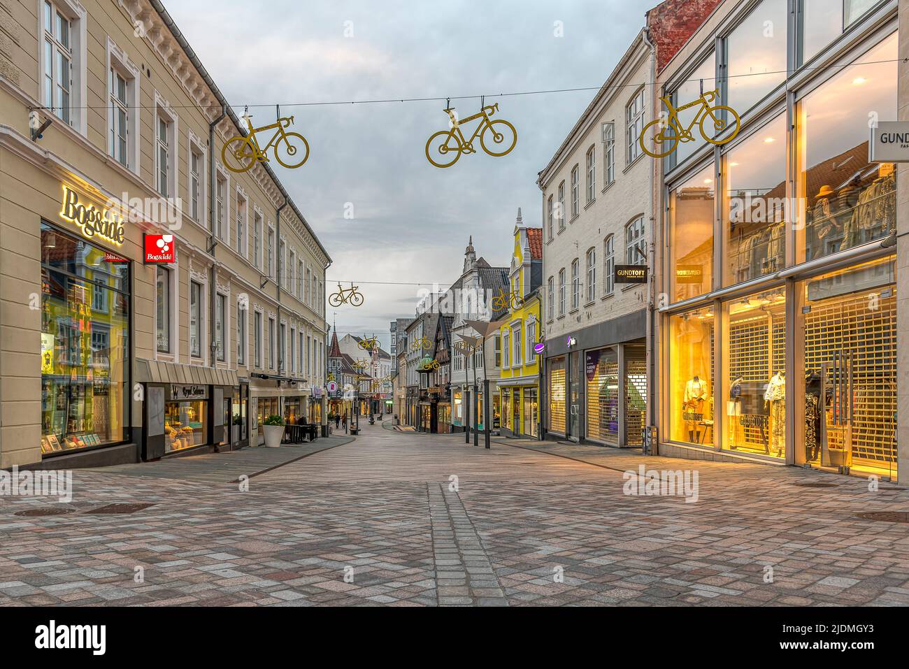 Fahrradlogos für die Tour de France hängen im sanften Abendlicht über der Einkaufsstraße in Vejle, Dänemark, 14. Juni 2022 Stockfoto