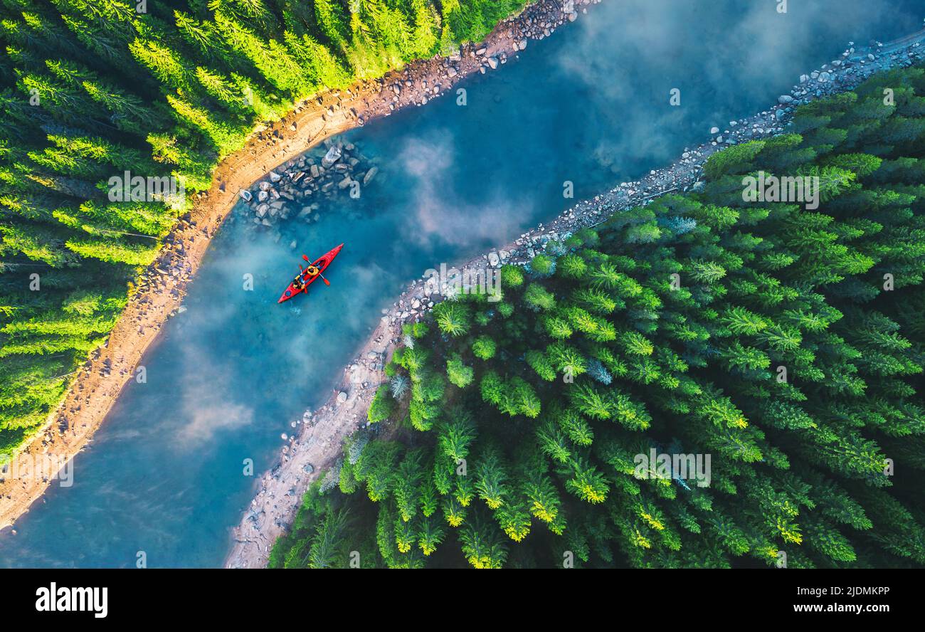 Luftaufnahme eines Rafting-Bootes oder Kanus in Bergfluss und Wald. Erholung und Camping Stockfoto