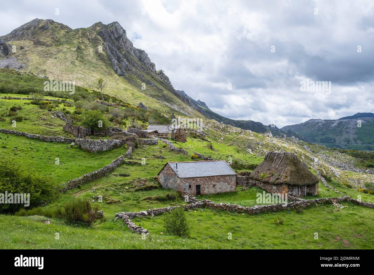Spanien, Asturien. Braña (Wiese) von Mumian im Naturpark von Somiedo. Die Stein- und Thatch-Hütten (Teitos), neben dem Farmer's House, dienen als Viehzüchter Stockfoto