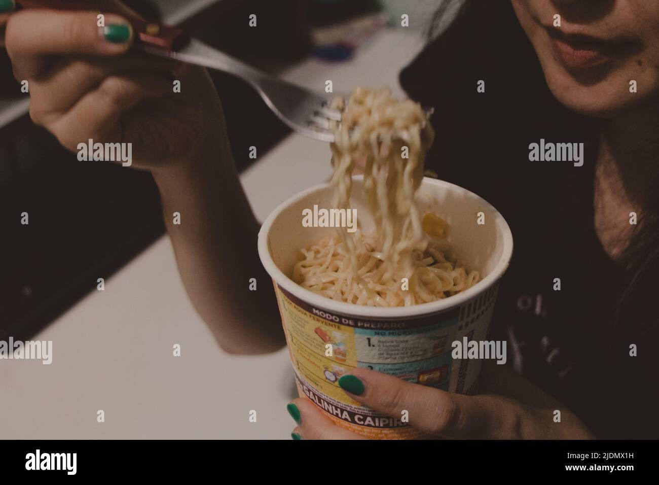 Teen Mädchen essen Nudeln in einer Tasse Stockfoto