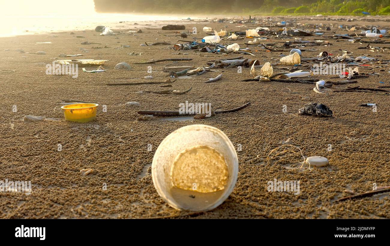 Plastikverschmutzung der Küste. Verschmutzte Ozeanstrände mit Plastikmüll, Müll mit Ozean im Hintergrund. Ökologische Katastrophe am Strand. Kunststoff Stockfoto