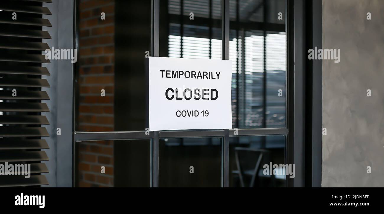 Das Schild vor dem Büro ist vorübergehend geschlossen. Melden Sie Coronavirus im Geschäft an. Stockfoto
