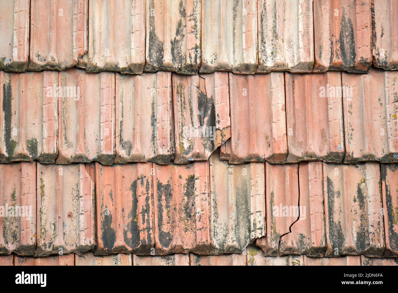 Nahaufnahme der verwitterten Keramikfliesen, die das Gebäudedach bedecken Stockfoto