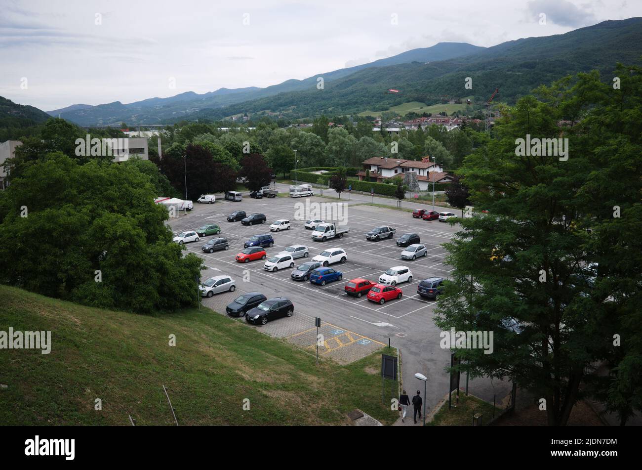 Borgo Val di Taro, Italien - Juni, 2022: Blick von oben auf den kostenlosen Parkplatz im Freien in der kleinen italienischen Stadt in Apenninen. Asphaltparkplatz, umgeben von Grün Stockfoto