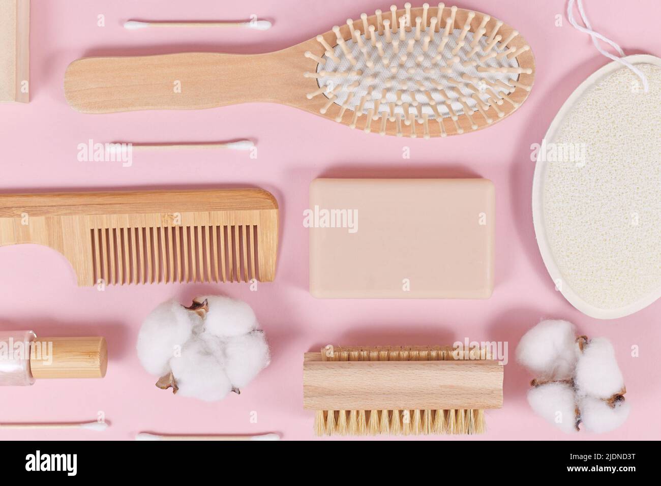 Umweltfreundliche Schönheits- und Hygieneprodukte aus Holz wie Kamm und Seife auf rosa Hintergrund Stockfoto