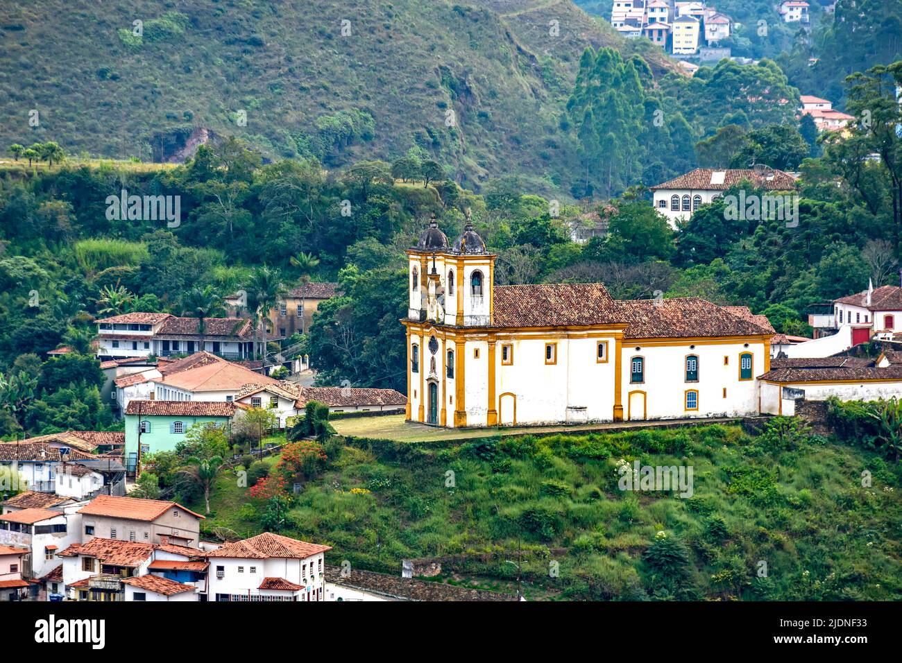 Blick von oben auf eine der mehreren historischen Kirchen im Barockstil in der Stadt Ouro Preto in Minas Gerais mit Häusern und Kolonialstil arou Stockfoto