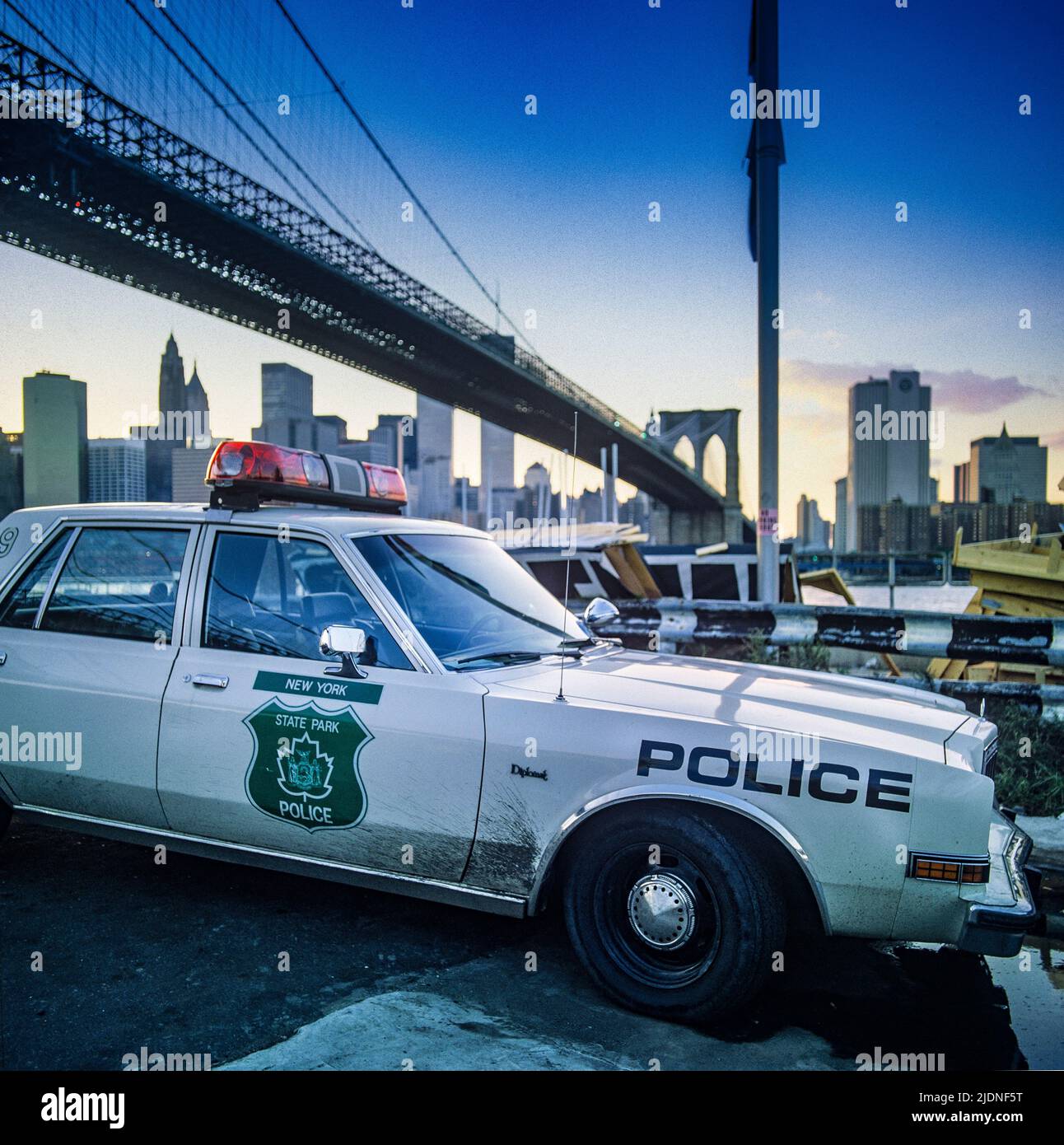 New York 1980s, State Park Polizeiauto, Brooklyn Bridge, Skyline von Lower Manhattan, Sonnenuntergang, New York City, NY, NYC, USA, Stockfoto