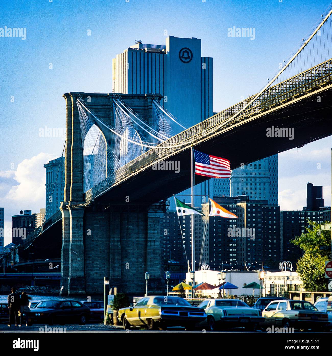 New York 1980s, Brooklyn Bridge, The River Cafe Terrace, Flaggen, NY Telefongesellschaft in der Ferne, Golden Hour, Manhattan, New York City, NY, NYC, USA, Stockfoto