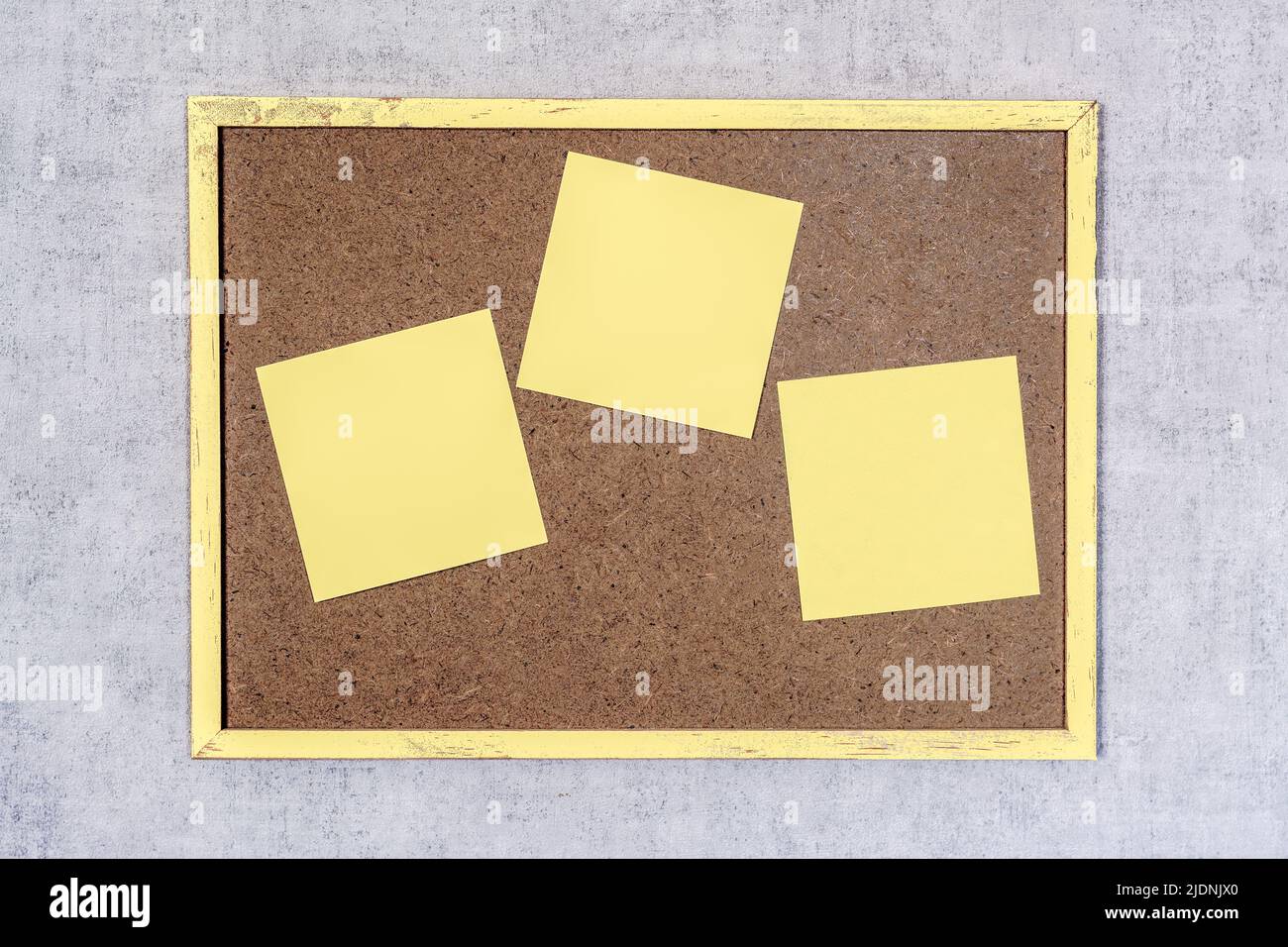 Drei gelbe Pfosten auf einem kleinen Holzbrett Stockfoto