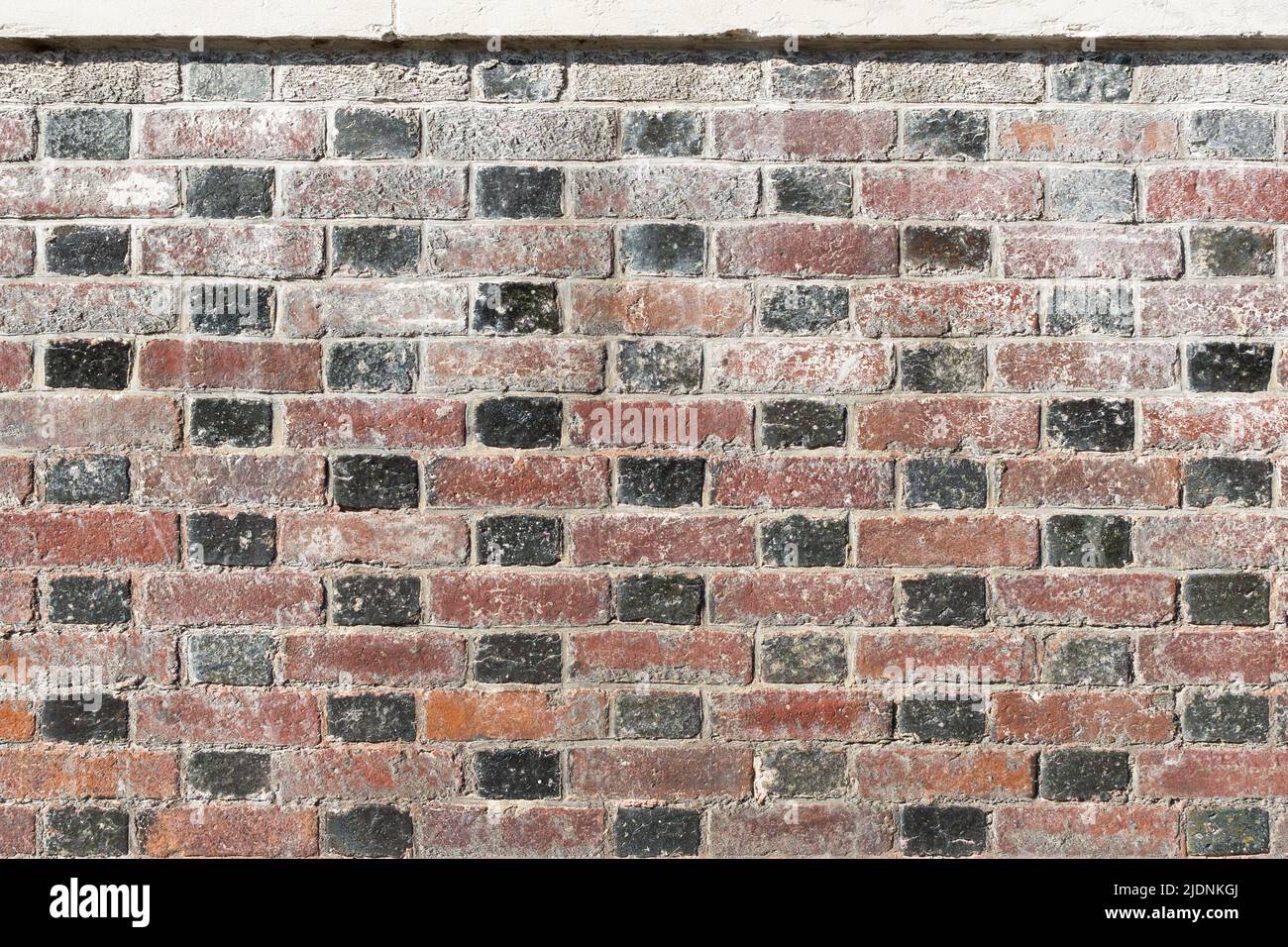 Rote und schwarze Ziegelmauer. Stockfoto