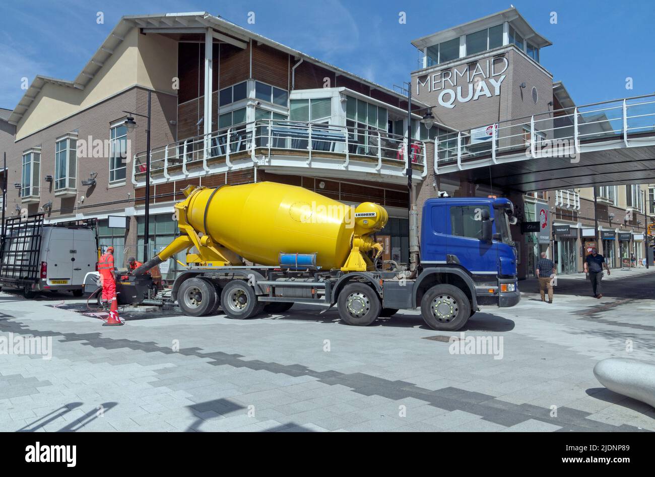 Gelber Transportbetonwagen, der am Mermaid Quay in Cardiff Bay arbeitet, Sommer 2022 Stockfoto